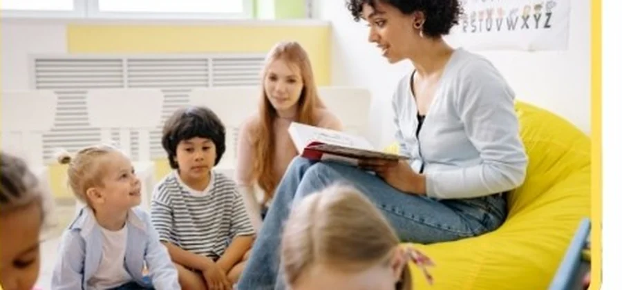 An educator reading a storybook to a group of attentive young children